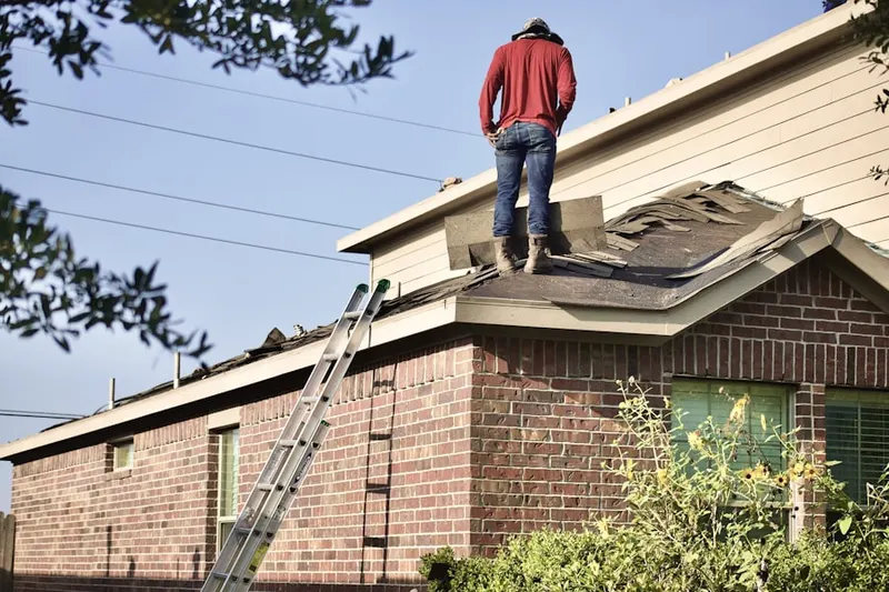 Professional roofer working on a residential roof in Gunter